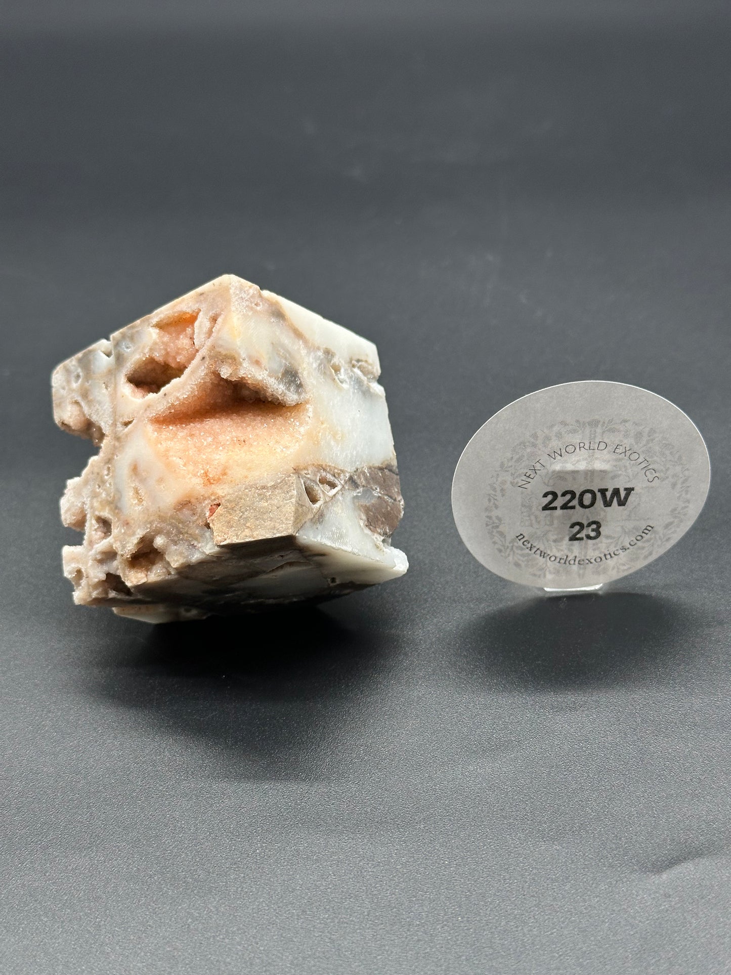 Sphalerite Cube (220W23): A detailed close-up of the mineral's textured surface, featuring a round white label with black text.