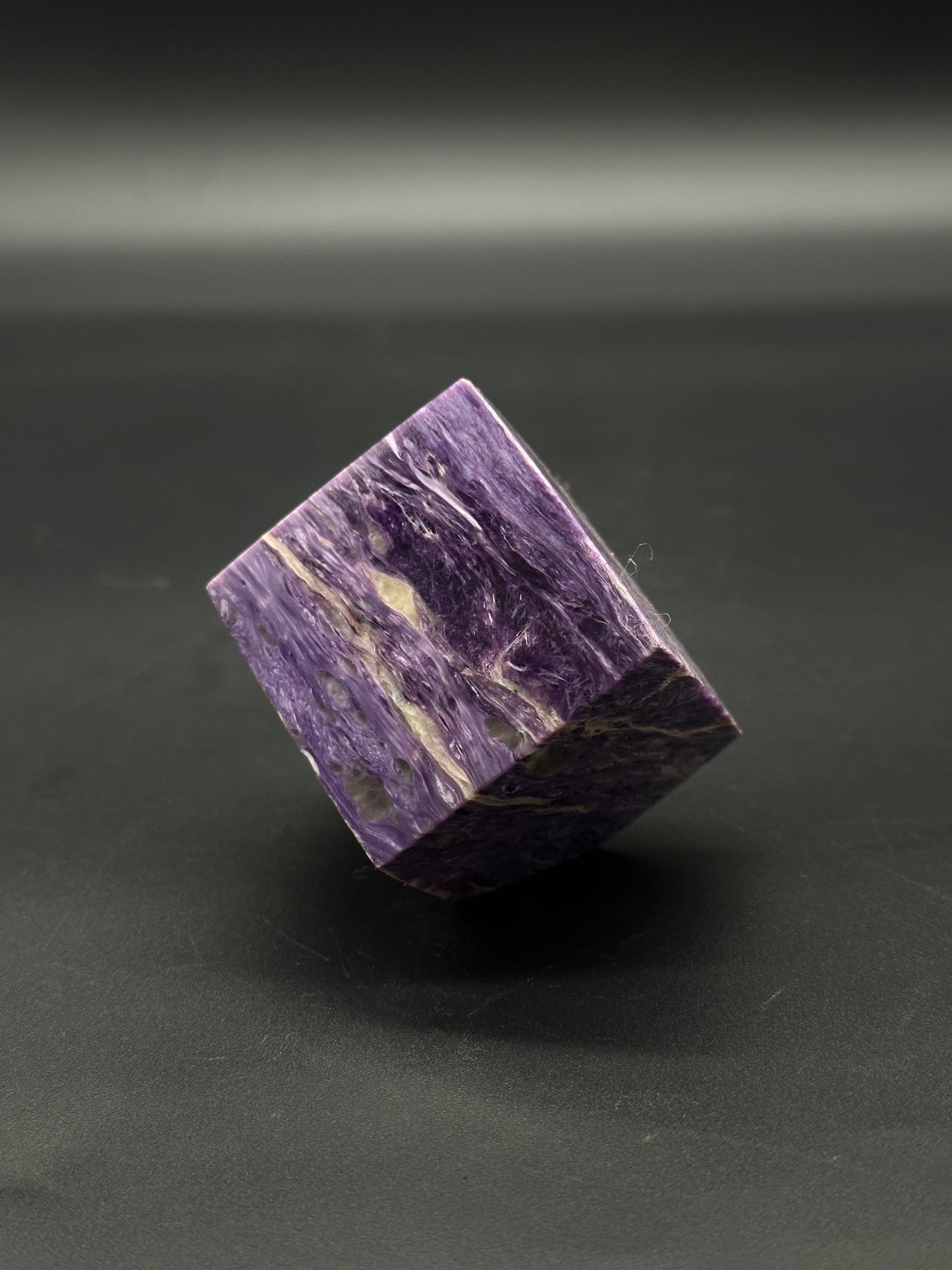 Charoite Cube (515W01) featuring a polished, geometric mineral structure, highlighting its natural patterns and smooth, reflective surfaces, ideal for collectors or crystal enthusiasts.