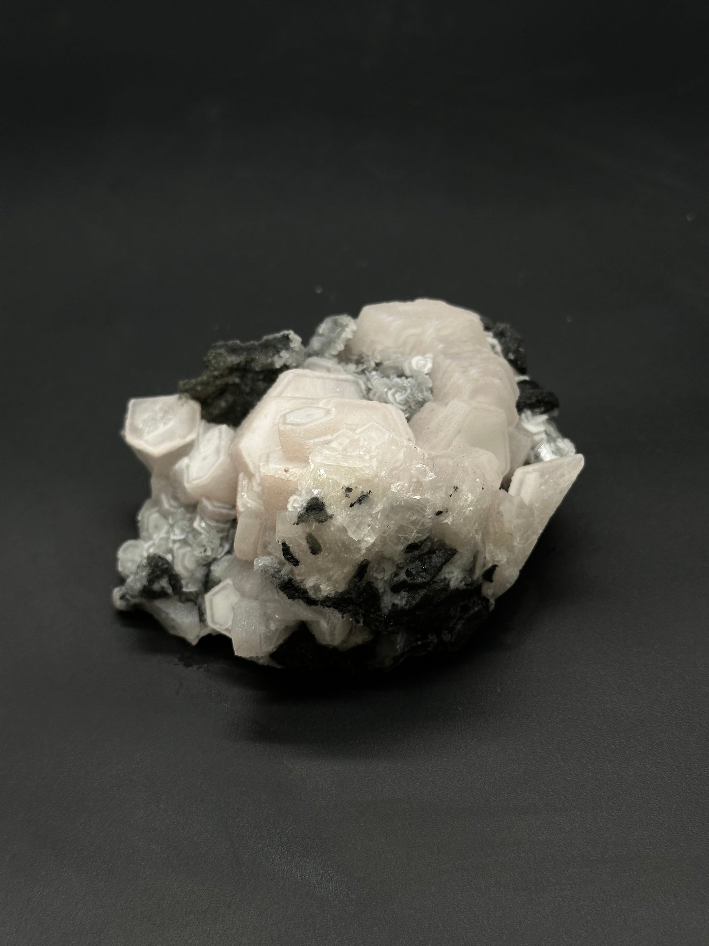 Raw Coin Calcite (508W28) displayed as a smooth, rounded mineral, showcasing its natural texture and unique formation.