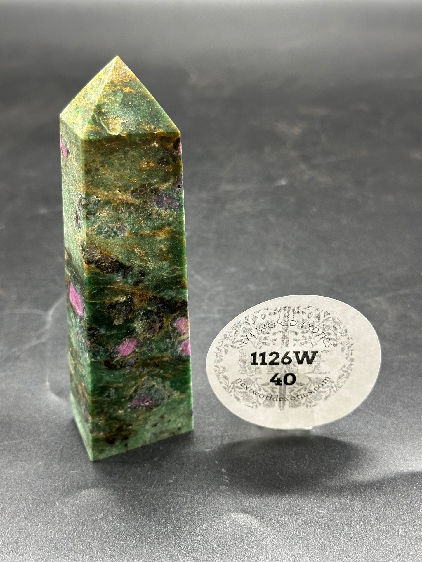 Ruby Zoisite Tower (1126W40) featuring a polished stone structure with a mix of green and pink hues, accompanied by a white sticker displaying black text and numbers.