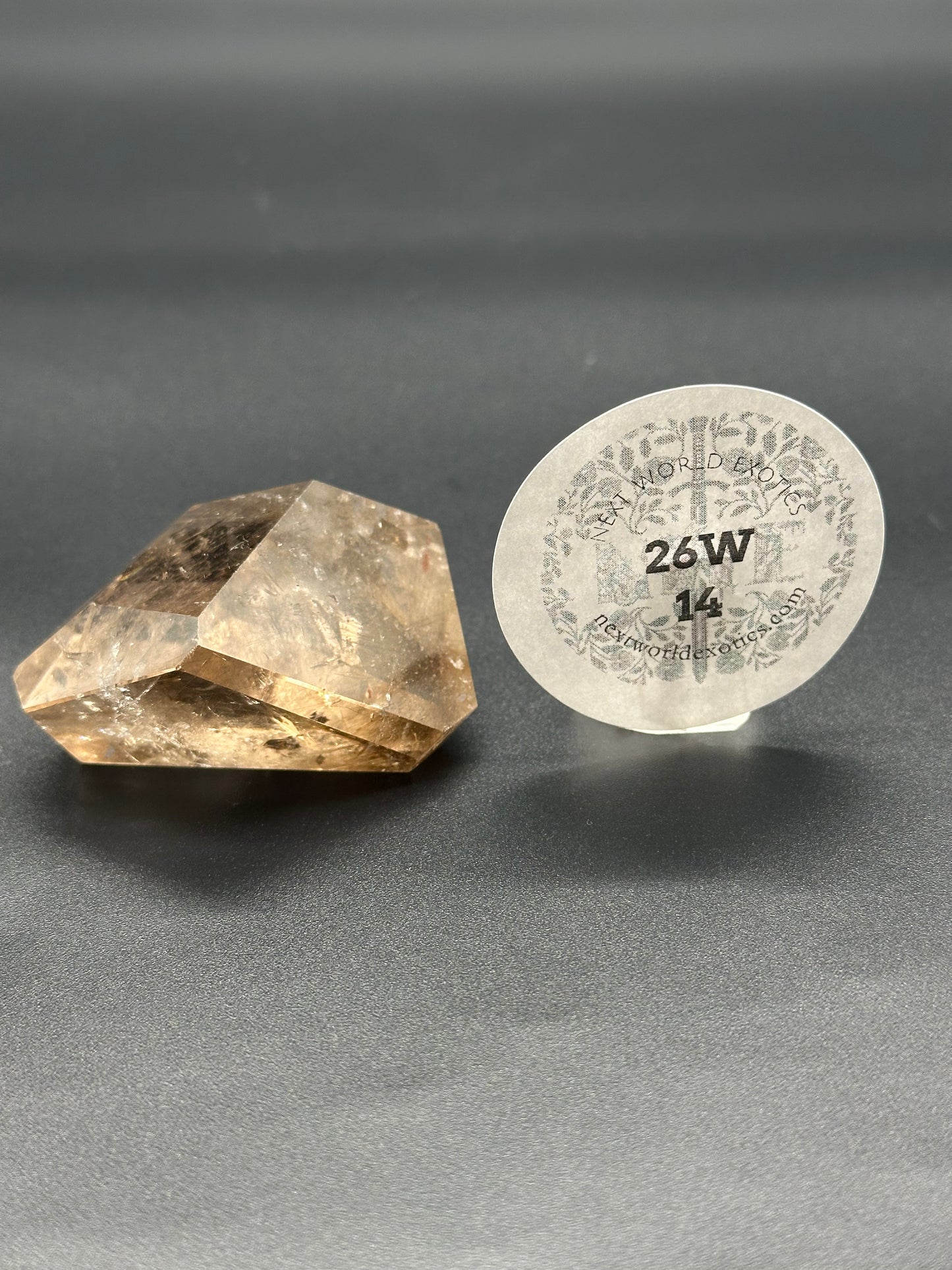 Smokey Garden Quartz (26W14) featuring a detailed crystal with a circular floral label, highlighting its intricate textures and unique mineral structure.
