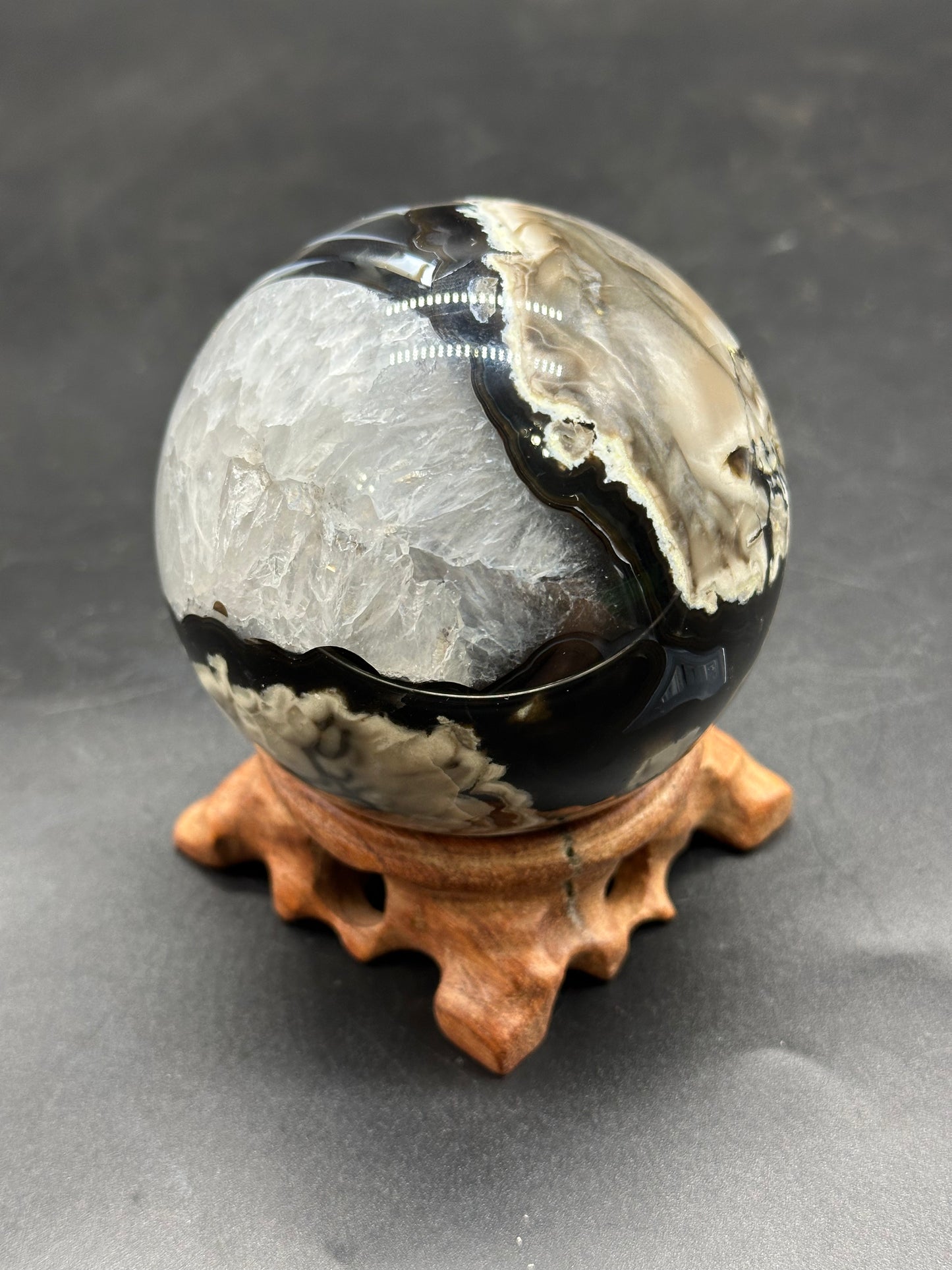 Volcanic Agate Sphere (1126W31) on a wooden stand, showcasing its polished, round form, ideal for crystal enthusiasts and mineral collectors.