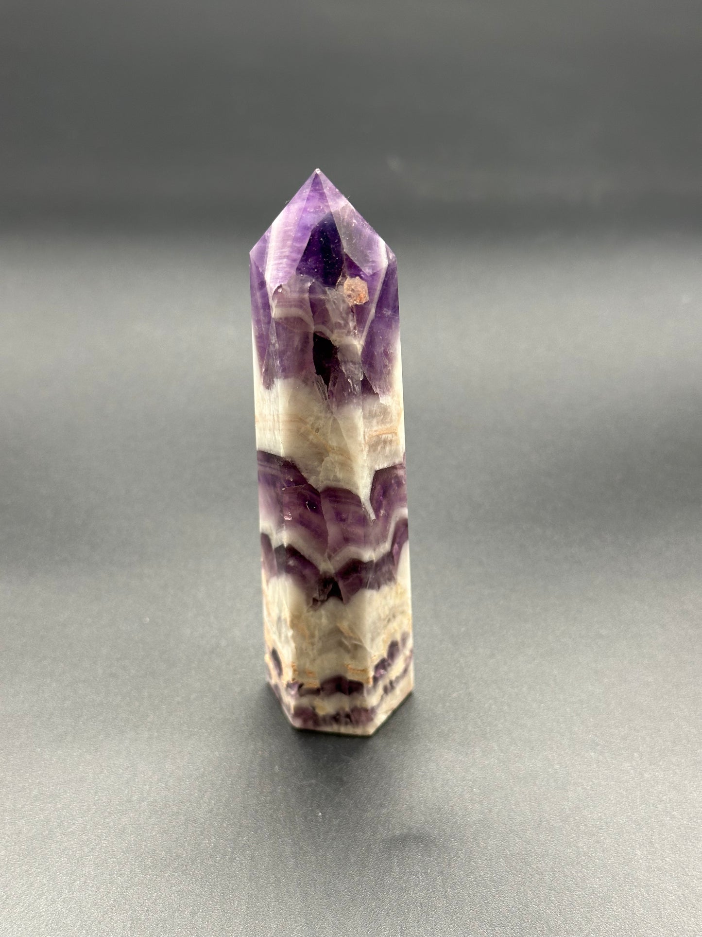 Dream Amethyst Tower (213W10) showcasing its striking purple and white crystalline structure, emphasizing its natural beauty and intricate details visible up close.