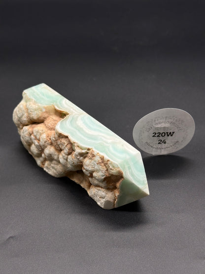 Caribbean Calcite Tower with Raw Edge, showcasing its natural mineral form, highlighted by a round white label for product identification.