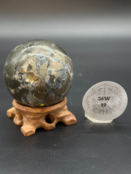 Nipomo Marcasite Sphere (36W19) displayed on a wooden stand, showcasing intricate gold and silver designs.