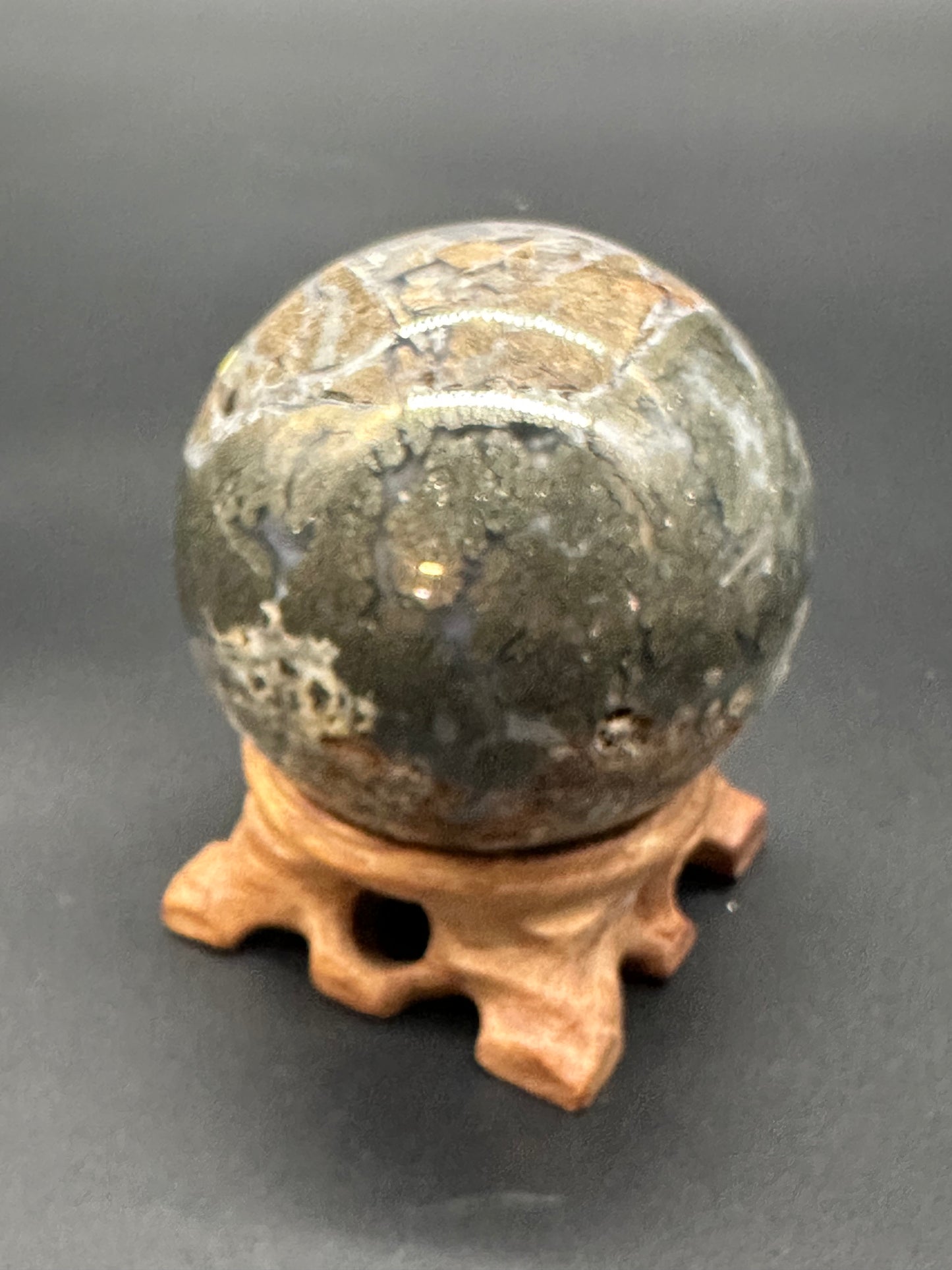 Nipomo Marcasite Sphere (36W19) displayed on a stand, showcasing its polished stone surface, emphasizing its artistic spherical form.