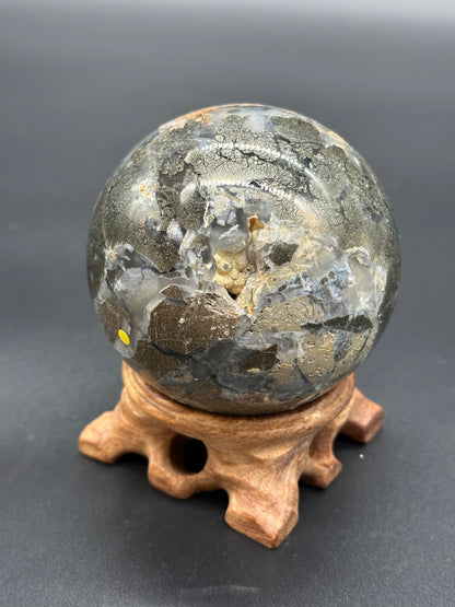 Nipomo Marcasite Sphere (36W19) displayed on a wooden stand, showcasing its cracked surface with gold and silver speckles, emphasizing its artistic mineral composition.