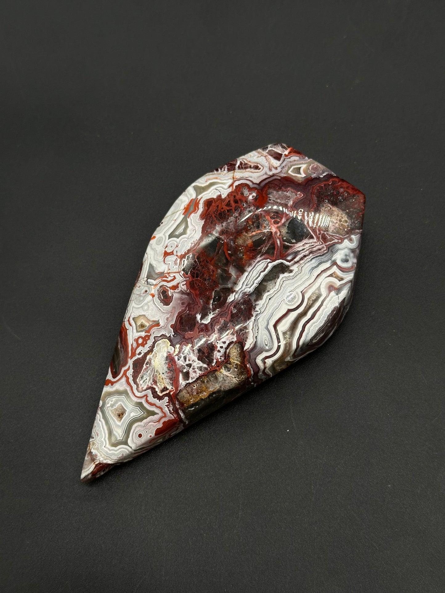 Mexican Crazy Lace Agate Free Form (812W09) features intricate lace-like swirling patterns, showcasing its polished cabochon shape, perfect for crystal enthusiasts or collectors.