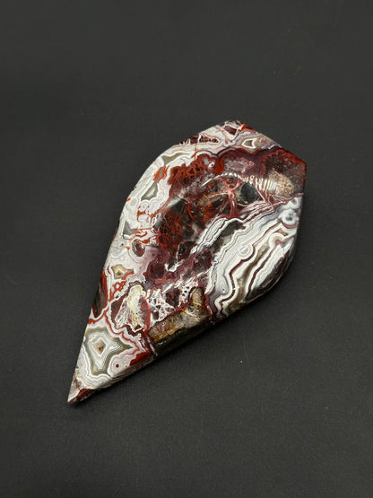 Mexican Crazy Lace Agate Free Form (812W09) features intricate lace-like swirling patterns, showcasing its polished cabochon shape, perfect for crystal enthusiasts or collectors.