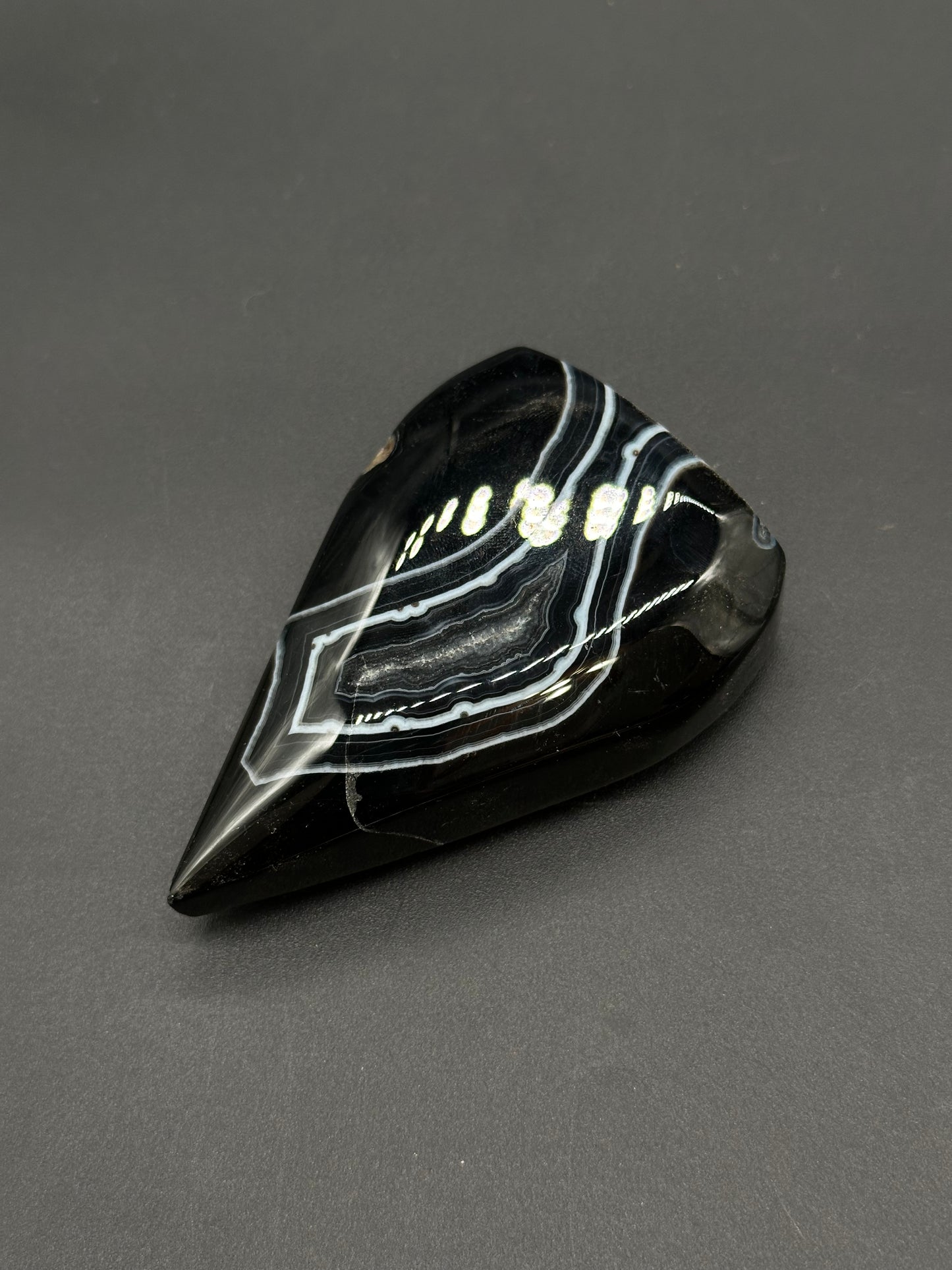 Black Agate Free Form (812W10) gemstone, teardrop-shaped with glossy black surface and striking white/grey banding, polished to perfection.