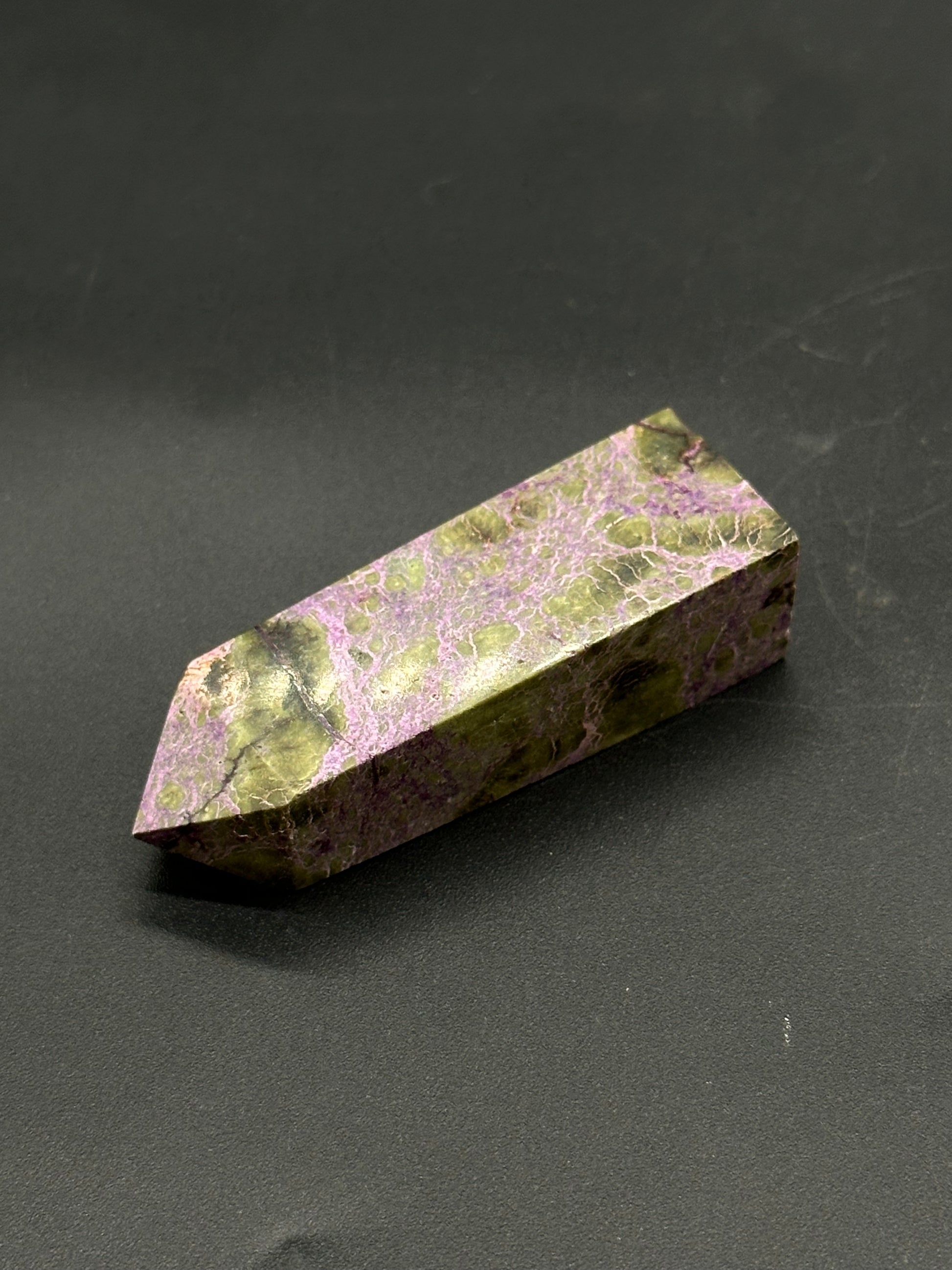 Atlantisite Tower (812W11) features a polished crystal wand with a distinctive pattern, representative of stichtite in serpentine.