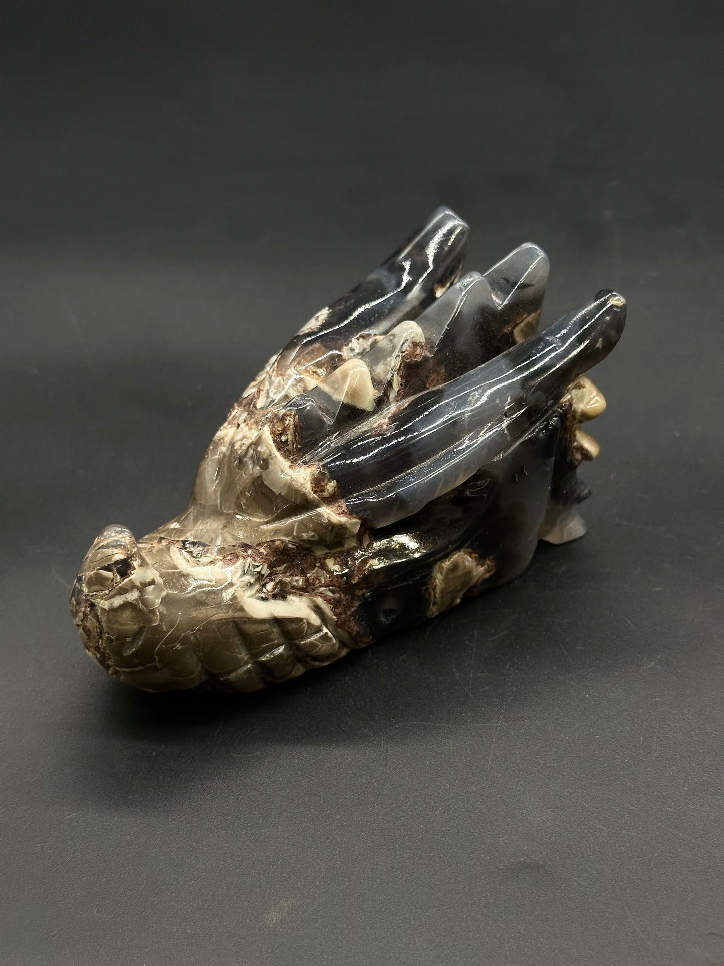 Volcanic Agate Dragon Carving (812W17) showcasing a polished stone dragon head with a snout, sweeping horns, and scale-like textures, crafted from banded agate/jasper.
