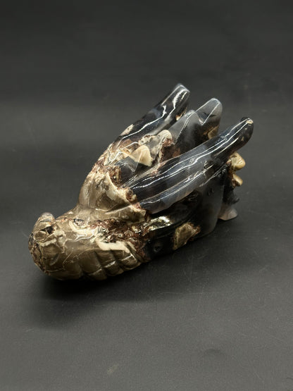 Volcanic Agate Dragon Carving (812W17) showcasing a polished stone dragon head with a snout, sweeping horns, and scale-like textures, crafted from banded agate/jasper.