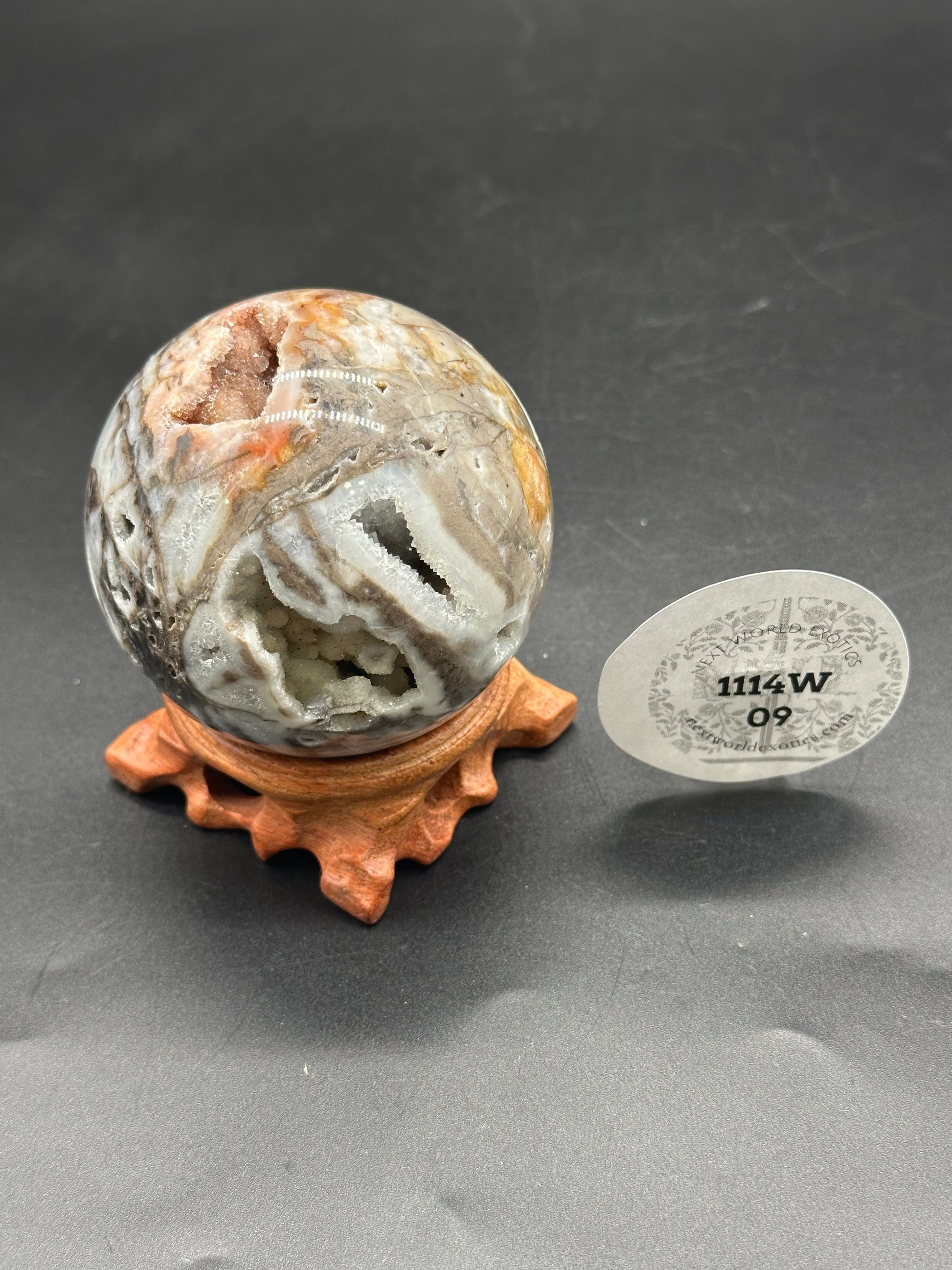 Sphalerite Sphere (1114W09) featuring a 2.65-inch diameter with a visible druzy cavern, presented on a stand, highlighting its unique texture and form.