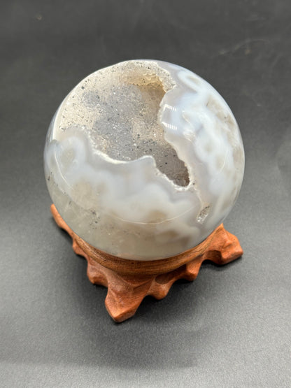 Agate Sphere with Duzy Caverns (1024W43) featuring a distinct central hole, showcasing intricate textures and unique mineral formations.