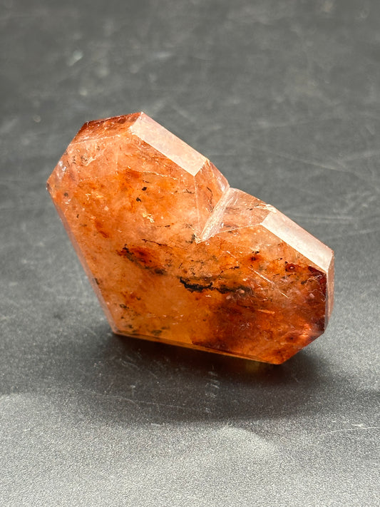 Fire Quartz Faceted Heart (1126W36) displayed in close-up, showcasing its intricate crystal structure and detailed faceting, highlighting its natural mineral beauty.