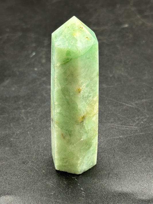 Quantum Quatro Tower (1126W39), a uniquely shaped mineral, displayed on a smooth surface, showcasing its intricate textures and natural formation details.