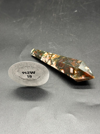 Red Moss Agate Scepter (912W18) featuring a large pointy stone and a round white tag displayed on a table.