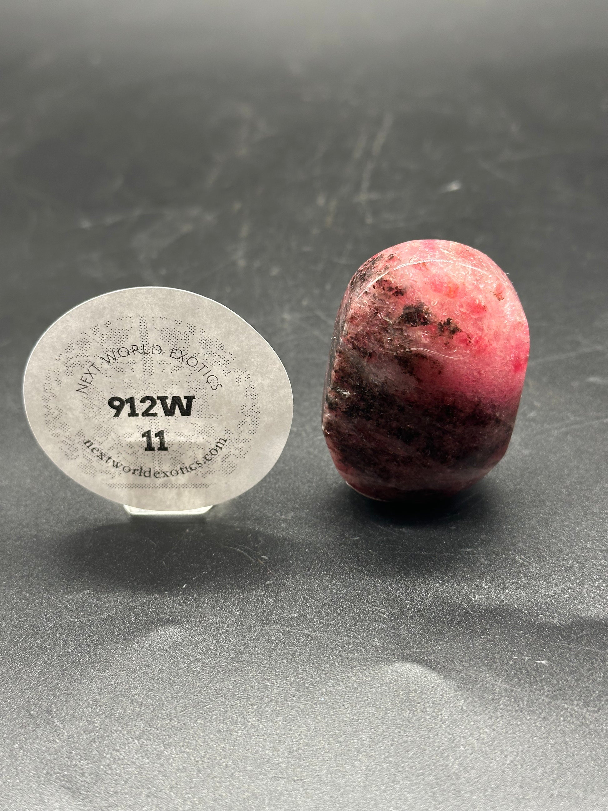 Rhodonite Palm Stone (912W11) with a smooth, speckled surface, notable for its distinct red and black patterns, showcased close-up.