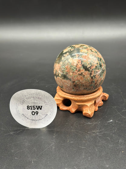 Rhodonite Sphere (815W09) on a stand, featuring a round marble-like design with visible black text and numbers on a white sticker.