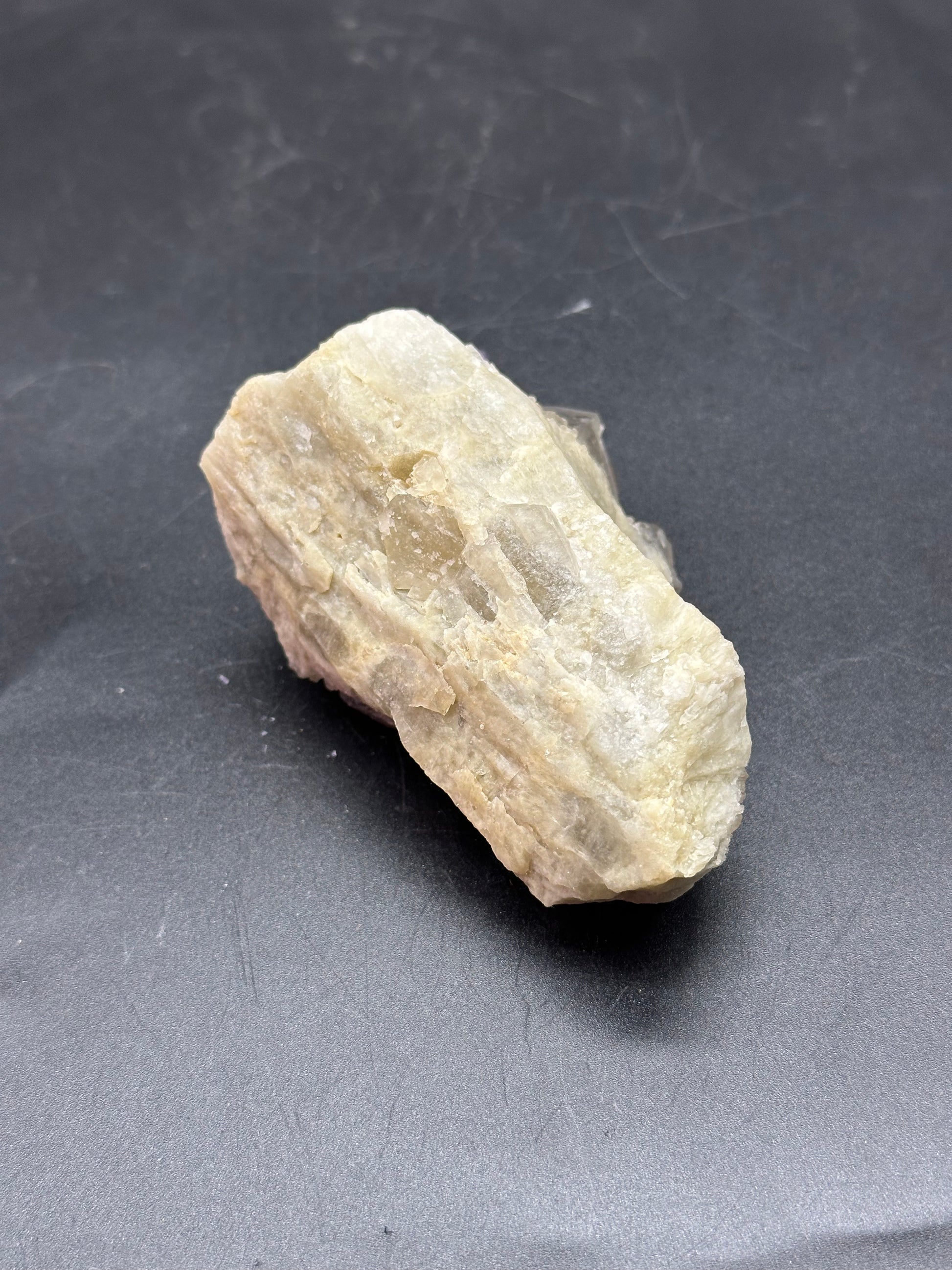 Yellow Pineapple Cluster Quartz (1017W51) displayed on a gray surface, showcasing its natural mineral form and igneous rock texture.